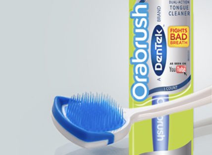 Dentek blue and white Orabrush with its packaging in the background