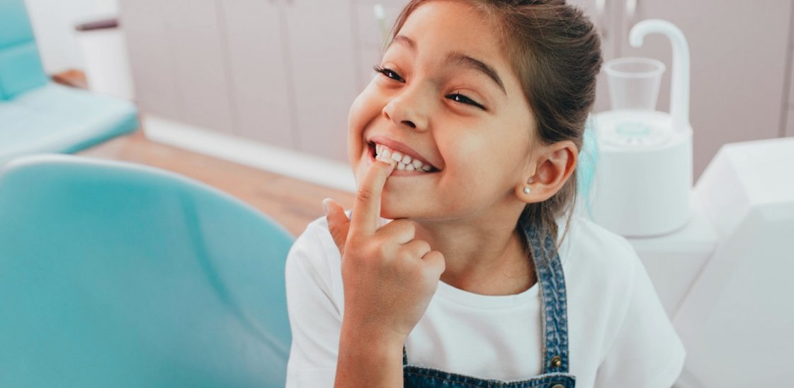 Little girl smiling showing her baby teeth