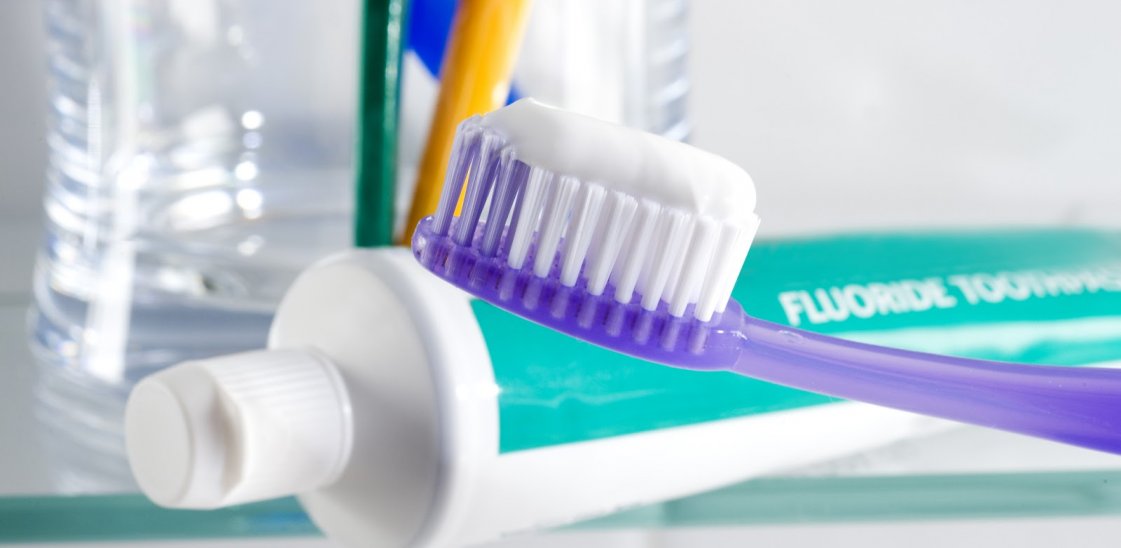 fluoride toothpaste next to a toothbrush