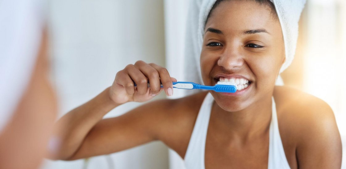 a woman brushing her teeth in a mirror