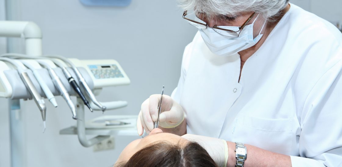 dentist carrying out oral surgery on a patient